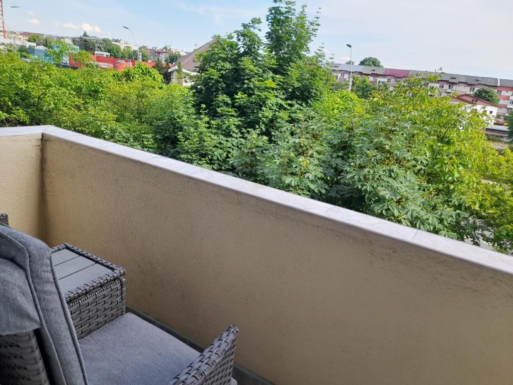 Balconul apartamentului, cu loc de relaxare și vedere spre verdeață