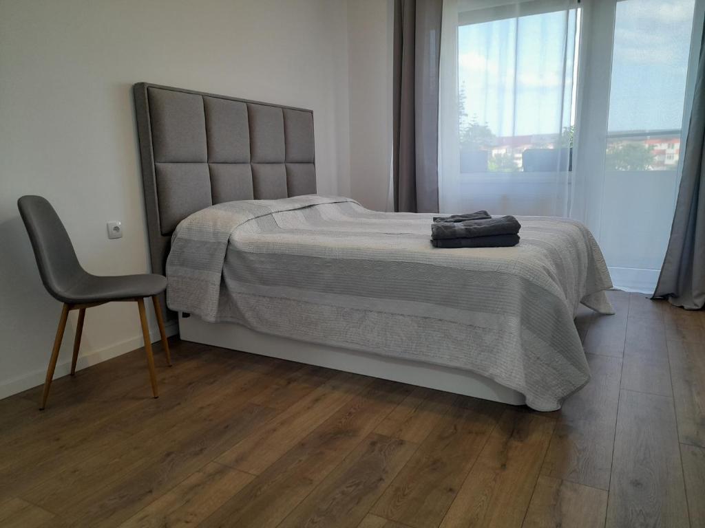 Dormitorul apartamentului Aldani, cu pat dublu și lumină naturală